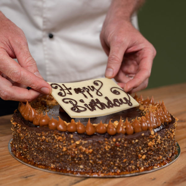 happy Birthday Plaquue on a Pembroke Patisserie Mud Cake